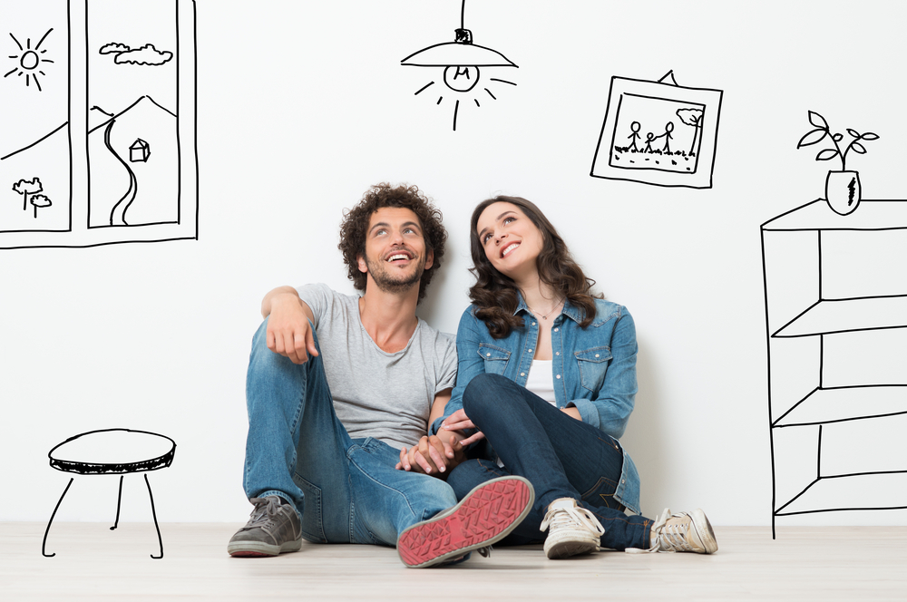 Portrait,Of,Happy,Young,Couple,Sitting,On,Floor,Looking,Up